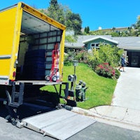 a yellow moving truck is parked in front of a house