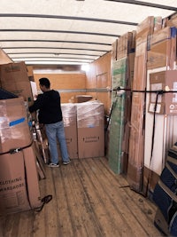 Mover stakes stuff in a box truck, furniture parts strapped on