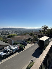 White truck parked in front house on a hill with gorgeous view 